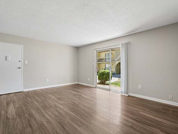 A room with a white door and a window with a view of a building outside.