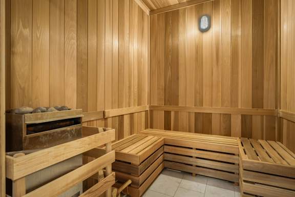 A wooden sauna with benches and a heater.
