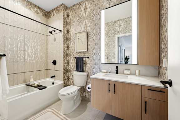 A bathroom with a white tub, toilet, and sink.