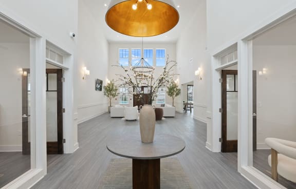 a living room with a table and a large vase in the center of it
