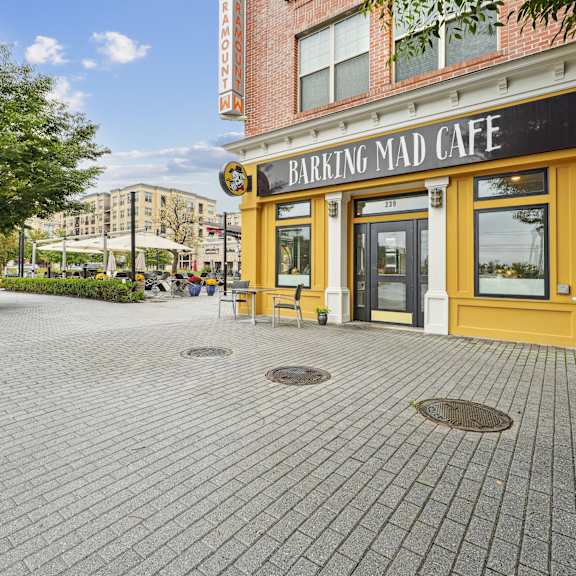 A brick building with a yellow trim and a sign that says "Barking Mad Cafe".