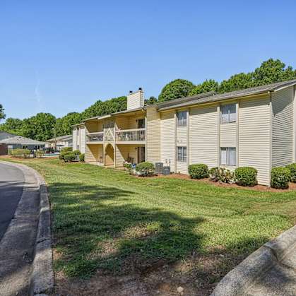 A residential building with a green lawn in front.