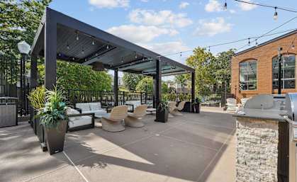 A patio area with a black awning and a stone wall.