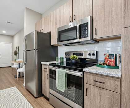 A modern kitchen with stainless steel appliances and wooden cabinets.