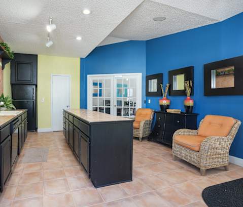 a lobby with a blue wall and orange chairs  at Cape Landing, Myrtle Beach, 29588