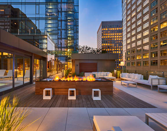 A modern outdoor seating area with a fire pit in the center.