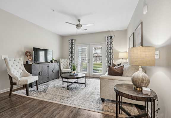 A living room with a white chair, a brown couch, and a wooden coffee table.