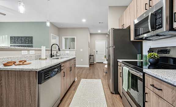 A modern kitchen with a black refrigerator and stove.