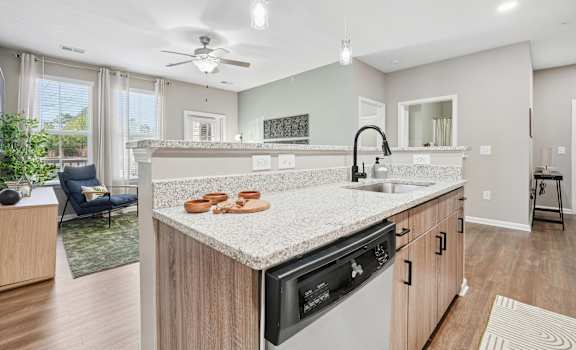 A modern kitchen with a large island and a dining area.