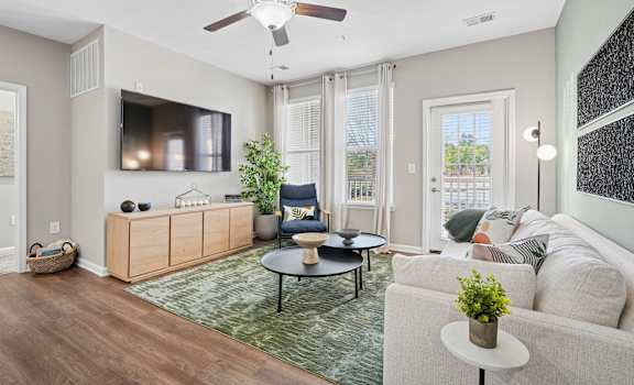 A living room with a white couch, a wooden cabinet, and a ceiling fan.