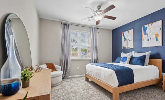 A bedroom with a bed, dresser, and mirror.