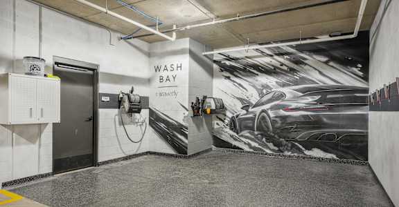 A car wash bay with a large mural of a car on the wall.