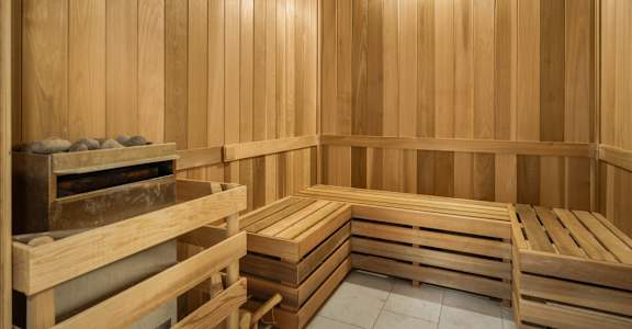 A wooden sauna with benches and a heater.