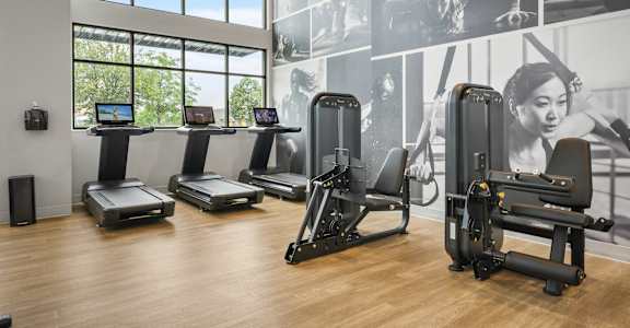 A gym with treadmills, exercise bikes and a wall of motivational posters.