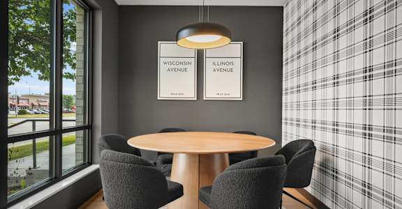 A conference room with a table and chairs and two signs on the wall.