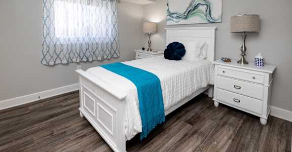 a bedroom with a white bed and a blue blanket at Fairbrook Park, Baltimore, MD