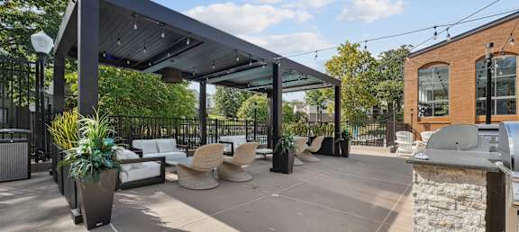 A patio area with a black awning and a stone wall.