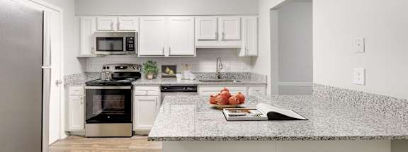 a kitchen with white cabinets and a granite counter top and