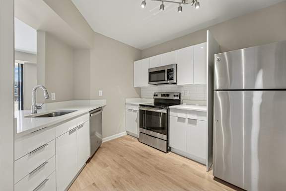 A modern kitchen with stainless steel appliances and white cabinets.