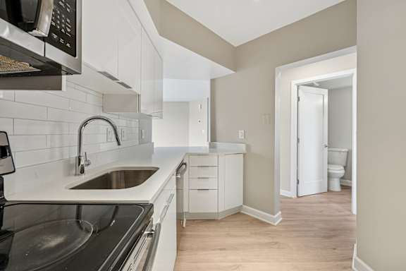 A kitchen with a sink and a microwave.