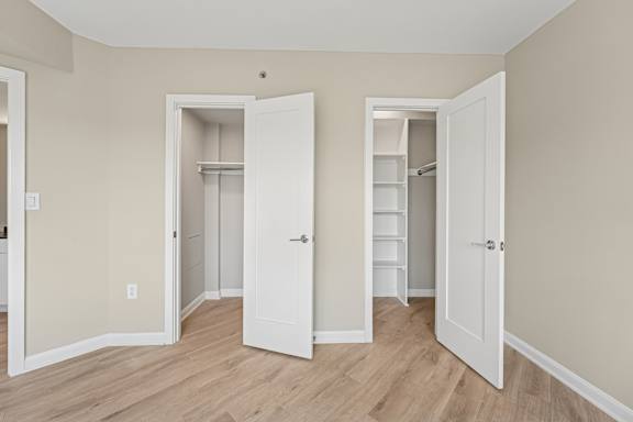 Three white doors open to reveal empty rooms.