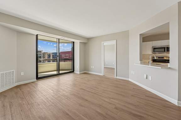 A room with a sliding glass door leading to a balcony.