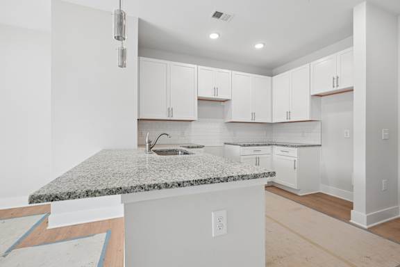 A kitchen with white cabinets and a granite countertop.