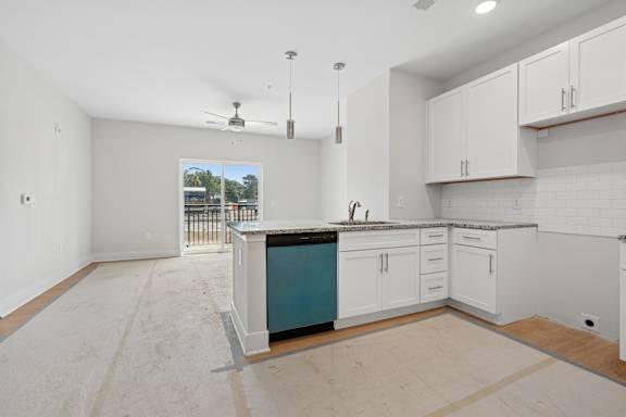 A kitchen with white cabinets and a blue island.