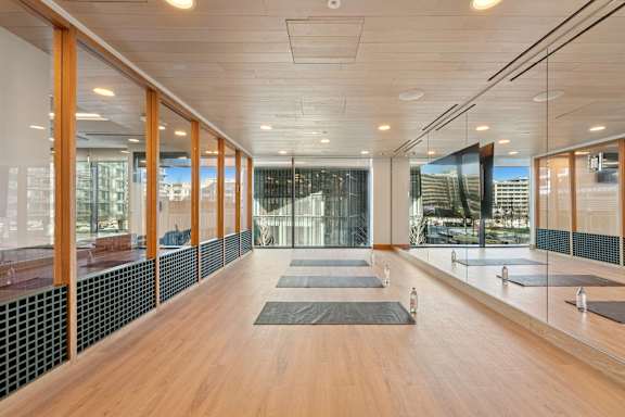 A yoga studio with wooden floors and mirrors on the wall.