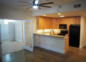 Thumbnail 4 of 14 - an open concept kitchen and living room with a ceiling fan
