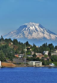 A small town sits in front of a large snow-capped mountain. at Aero Apartments, Tacoma