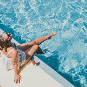 Crystal clear swimming pool with trees around  at Trinity Apartments, Irving, TX, 75061