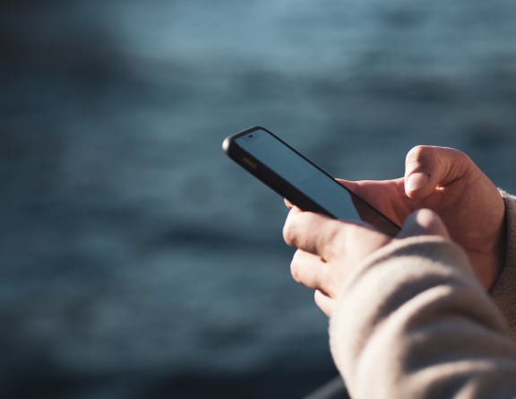 a person holding a cell phone in their hand
