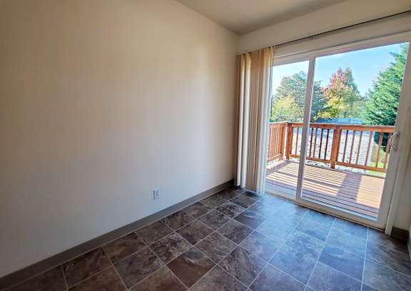 A room with a sliding glass door leading to a deck.