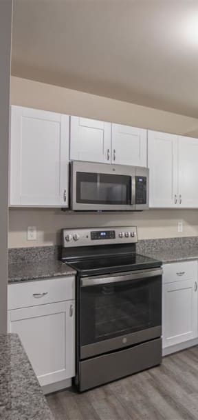 a kitchen with white cabinets and a black stove and refrigerator
