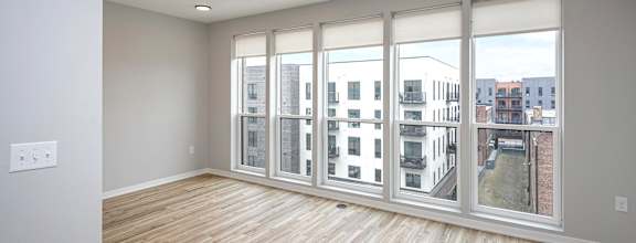 A room with a large window and wooden flooring.