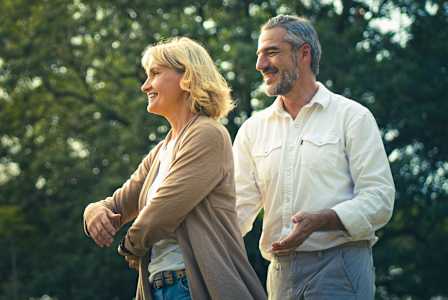 A man and a woman are standing in a park.