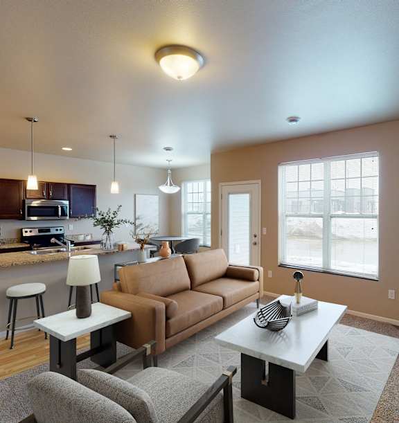 A modern living room with a fireplace and a kitchen area in the background.