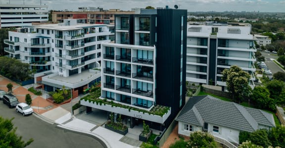 an aerial view of an apartment complex with cars parked in front of it