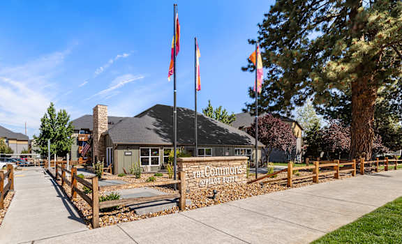 a building with flags and a sidewalk in front of it