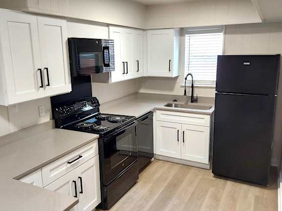 a kitchen with black appliances and white cabinets