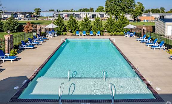 A large outdoor swimming pool surrounded by blue lounge chairs.
