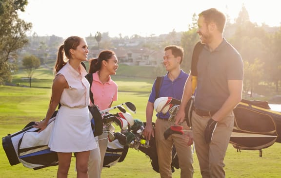 a group of people standing on a golf course
