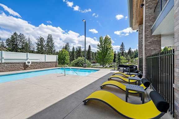 A pool with a yellow bench next to it.