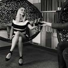 A man is toasting with a woman in a black and white photo.