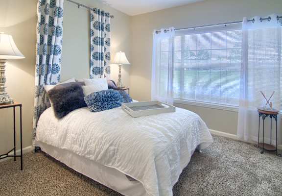 Enclave at Wolfchase Apartments in Cordova Tennessee photo of a bedroom with a bed and two windows