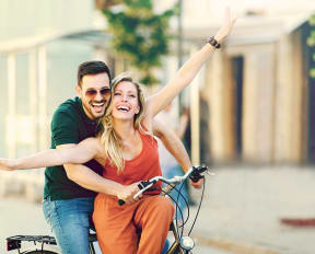 a man and a woman riding a bike on a street