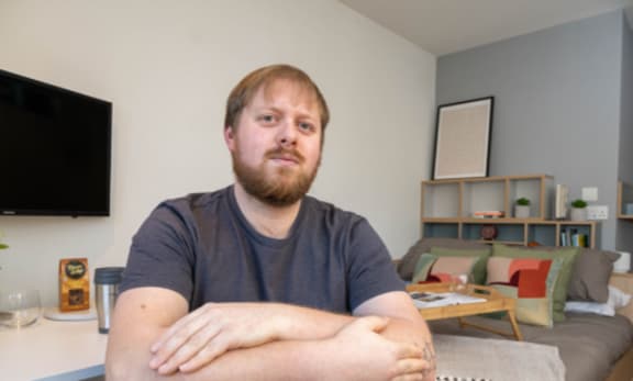 a man sitting in a living room with his arms crossed