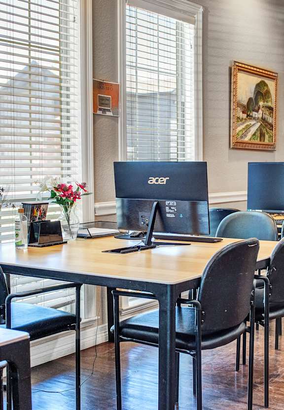 a conference room with desks and chairs and computers