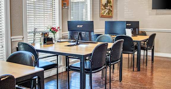 a conference room with desks and chairs and computers